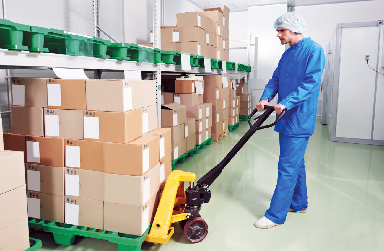 medical warehouse worker with manual lift loader